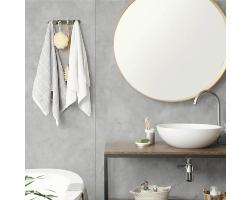 Moderne badkamer met ronde spiegel, witte waskom op een houten wastafelblad en grijze wand met betonlook.