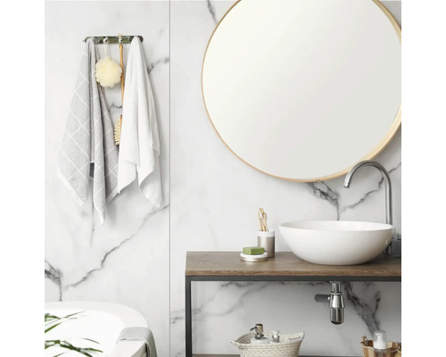 Lichte badkamer met witte marmeren wand, ronde spiegel, witte keramische opzetwastafel op houten meubel en chromen kraan.