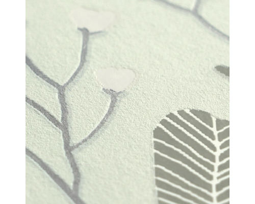 Close-up van vliesbehang met bloemenpatroon en voelbare textuur.