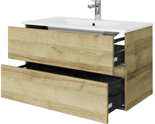 Wastafelonderkast met twee geopende laden in houtlook, witte wastafel en verchroomde kraan.