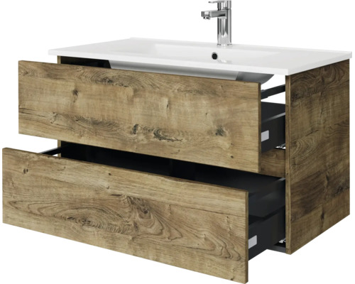 Modern badmeubel met twee open lades in eikenlook, inclusief witte keramische wastafel en verchroomde kraan.