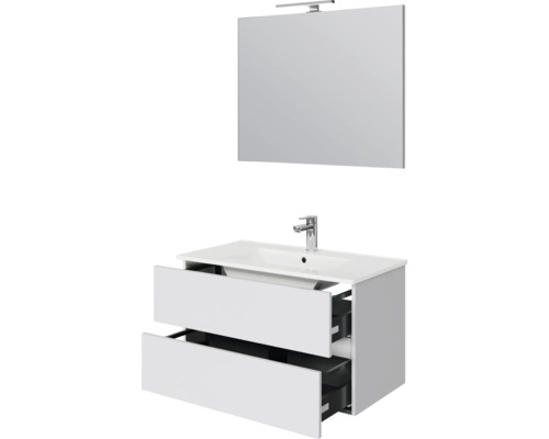 Witte wastafelonderkast met twee open laden, wastafel, verchroomde kraan en rechthoekige spiegel met lamp.
