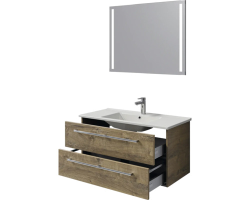 Moderne badkamermeubelset met verlichte spiegel, witte wastafel en onderkast in houtlook met twee geopende lades.