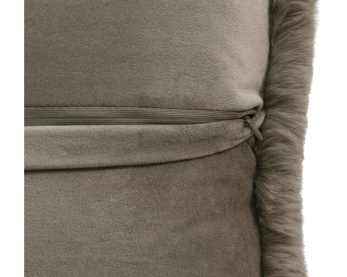 Close-up van een taupe fluwelen kussen met een verborgen rits en een rand van imitatiebont.