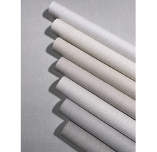 Diverse behangrollen in neutrale tinten met een gestructureerd oppervlak en zigzagpatroon.