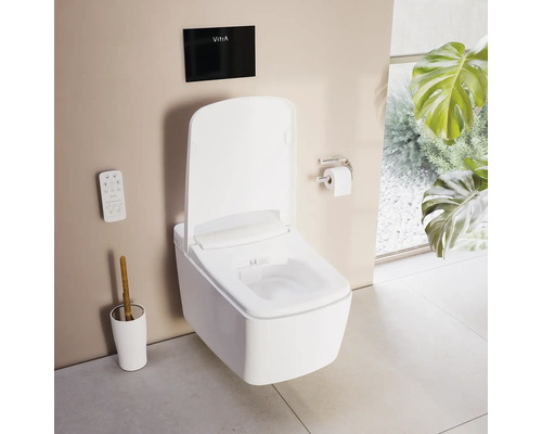 Wandhangend douchetoilet in wit met afstandsbediening en zwart bedieningspaneel met VitrA Logo in een lichte, georganiseerde badkamer.