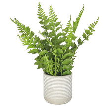 Kunstmatige varenplant in een geribbelde bloempot als decoratieve kamerplant.