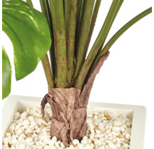 Kunstplant in een vierkante plantenbak met witte siersteentjes in de pot.