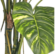 Detailopname van een kunstmatige Monstera plant met natuurgetrouwe bladeren en stengels.