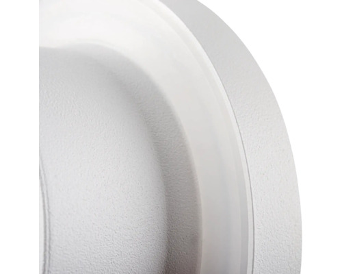 Detailopname van een ronde lamp met een gestructureerd oppervlak en een gladde rand.