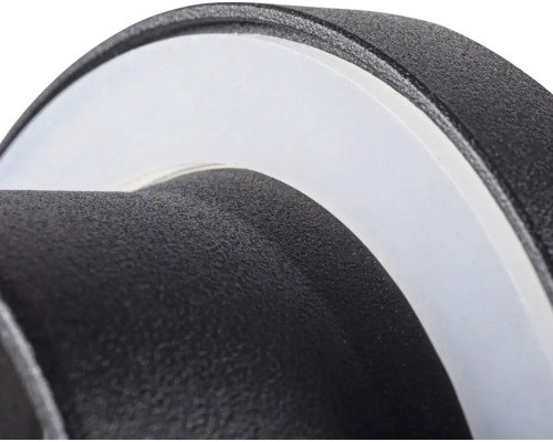Close-up van een ronde zwarte buitenlamp met gestructureerd oppervlak en witte diffusor.