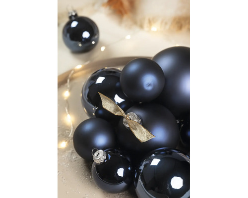 Zwarte kerstballen in verschillende maten, mat en glanzend, één bal versierd met een gouden strik.