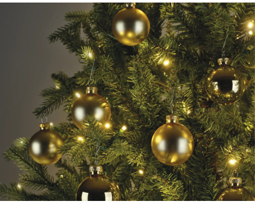 Kerstboom versierd met goudkleurige kerstballen in mat en glanzend en een warm witte lichtsnoer.