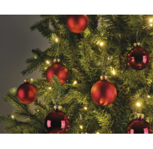 Kerstboom versierd met matte en glanzende rode kerstballen en warmwitte LED-lampjes.