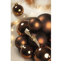 Bronskleurige kerstballen in matte en glanzende uitvoering, gerangschikt met een decoratieve lichtslinger.