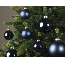 Blauwe kerstballen in verschillende maten, deels mat en deels glanzend, aan een groene kerstboom.