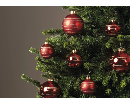 Rode kerstballen met gouden glitterlijnen in een versierde kerstboom.