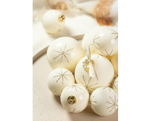 Crèmekleurige glazen kerstballen met goudkleurig glittersterpatroon in verschillende maten.