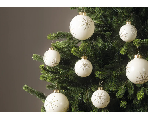 Witte kerstballen met gouden sterpatroon hangend aan de takken van een groene kerstboom.