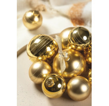 Gouden kerstballen in verschillende maten met glanzende en matte afwerking, deels gedecoreerd met glitterstrepen.
