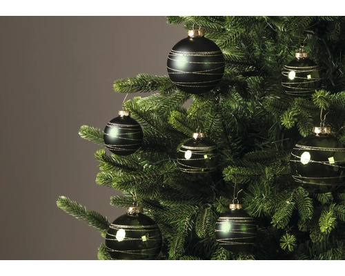 Donkergroene kerstballen met gouden glitterstrepen aan een kerstboom.