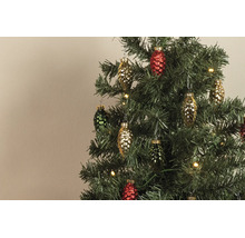 Gekleurde glazen hangers in de vorm van dennenappels aan een kunstkerstboom met warmwitte lampjes.