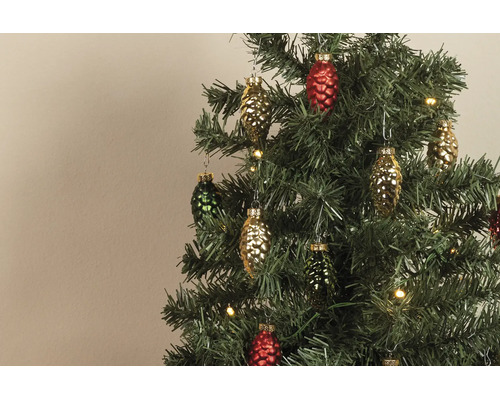 Gekleurde glazen hangers in de vorm van dennenappels aan een kunstkerstboom met warmwitte lampjes.