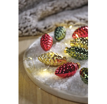 Kerstdecoratie in de vorm van dennenappels op kunstsneeuw met een lichtsnoer op een houten dienblad.