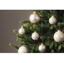 Kerstballen met glinsterend sneeuwvlokpatroon aan de takken van een kerstboom.