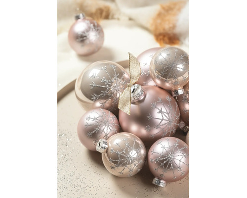 Roze kerstballen met een zilveren glittersneeuwvlokkenpatroon, mat en glanzend, gedecoreerd met een gouden strik.