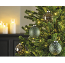 Kerstboom versierd met glazen kerstballen in groen en brons, voorzien van sneeuwvlokpatronen en verlicht met warmwitte lichtjes.