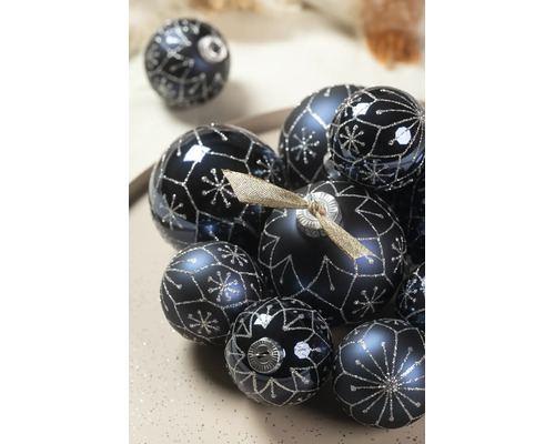 Donkerblauwe kerstballen met zilveren sneeuwvlokken en geometrische glitterpatronen in verschillende maten.