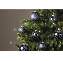 Donkere kerstballen met zilveren glitterpatronen hangend in een groene kerstboom met warmwitte lichtjes.