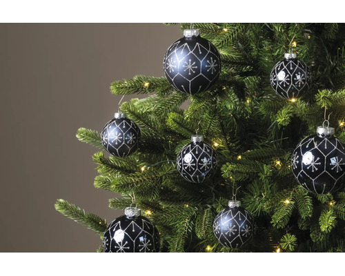 Donkere kerstballen met zilveren glitterpatronen hangend in een groene kerstboom met warmwitte lichtjes.