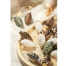Kerstboomversiering in de vorm van dennenappels op een houten bord met glitters en feestelijke verlichting.