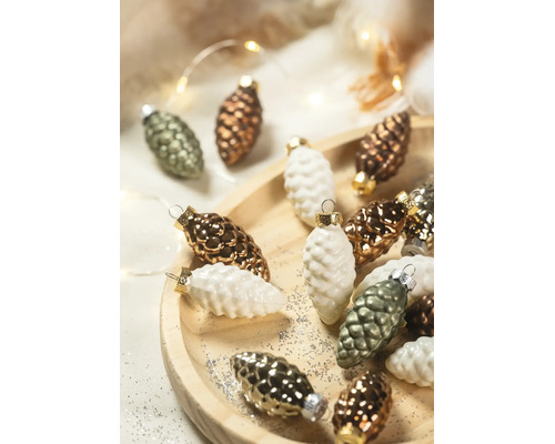 Kerstboomversiering in de vorm van dennenappels op een houten bord met glitters en feestelijke verlichting.