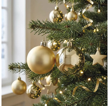 Close-up van een kerstboom versierd met matte en glanzende kerstballen, sterren, een lichtsnoer en decoratielint.