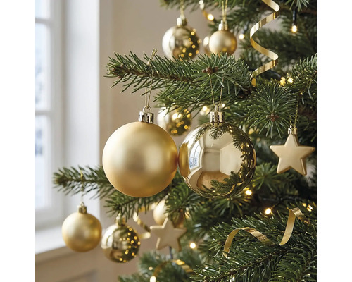 Close-up van een kerstboom versierd met matte en glanzende kerstballen, sterren, een lichtsnoer en decoratielint.