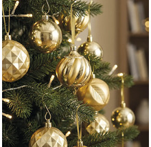 Kerstboom versierd met diverse gouden ornamenten en warmwitte lampjes.
