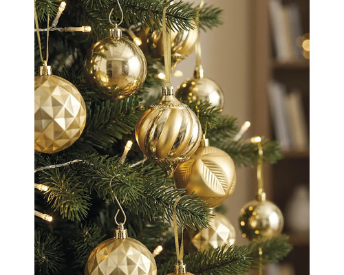 Kerstboom versierd met diverse gouden ornamenten en warmwitte lampjes.