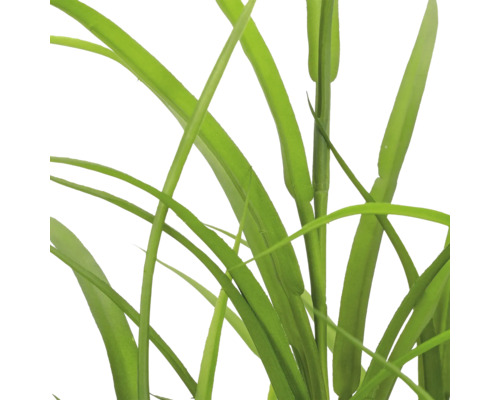 Detailopname van kunstmatig siergras met lange, smalle groene bladeren van kunststof.