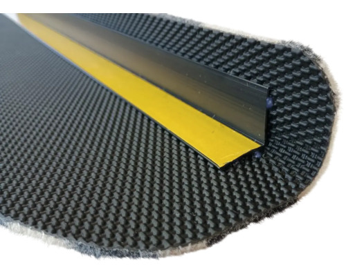 Zelfklevend trapneusprofiel op gestructureerde rubberen mat met gele plakstrip.