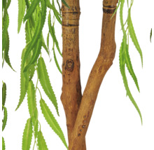 Detailweergave van een kunstplant met een getextureerde stam en lange, smalle groene bladeren.