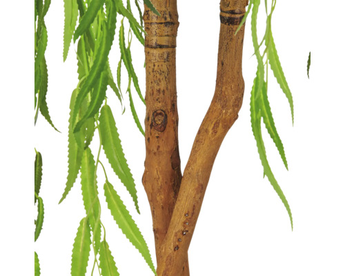 Detailweergave van een kunstplant met een getextureerde stam en lange, smalle groene bladeren.