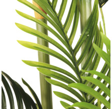 Detailopname van een kunstpalm met groene bladeren en stammen.