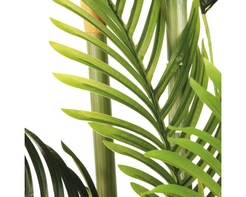 Detailopname van een kunstpalm met groene bladeren en stammen.