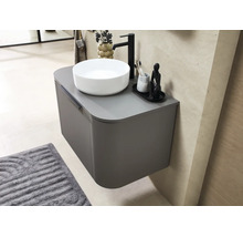 Hangend wastafelmeubel met afgeronde hoeken, een witte opzetwastafel en een zwarte kraan in een moderne badkamer.