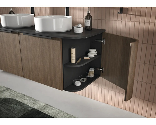 Modern dubbel wastafelmeubel met houten lamellenfronten, donker werkblad en een open, gebogen zijplank met toiletartikelen.