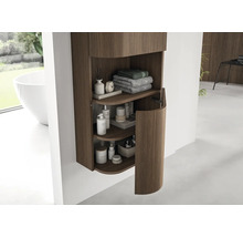 Moderne badkamer hangkast met verticale houten latten en een ronde deur, ingericht met handdoeken en verzorgingsproducten.