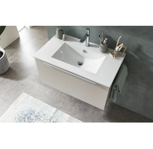 Modern wandhangend badkamermeubel met witte wastafel, beige onderkast en chromen kraan in een lichte badkamer.